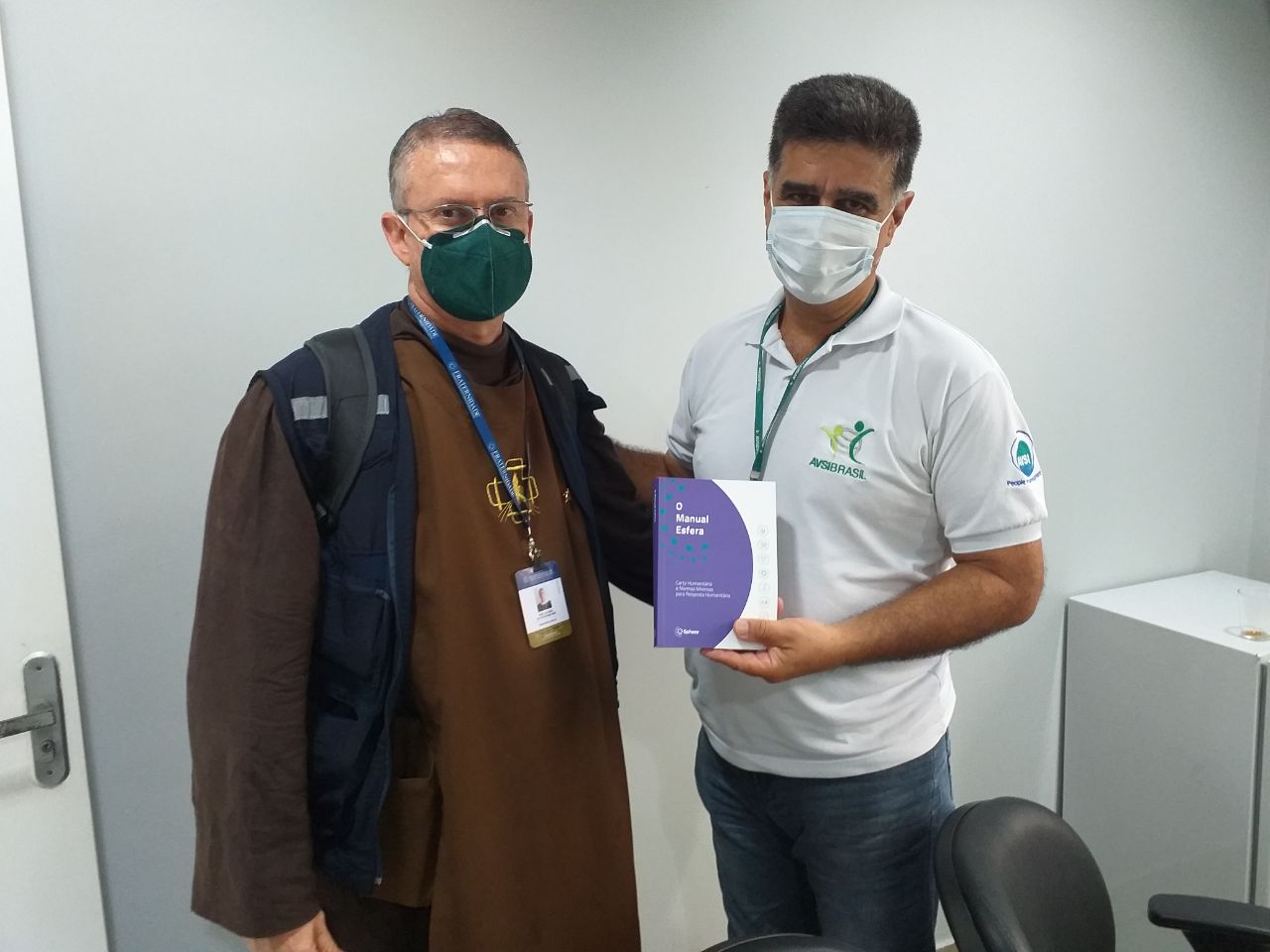 Le membre du Comité directeur de Sphère frère Luciano remet un manuel Sphère en portugais à Eli Mansur d’AVSI Brasil dans l’État du Roraima, au Brésil.